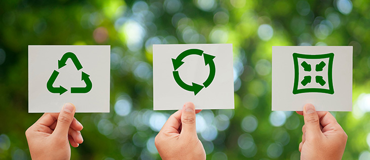 Três mãos segurando papéis com os três símbolos representando a reciclagem.